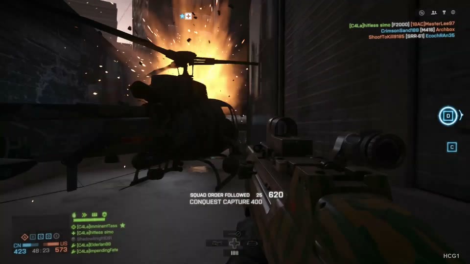 Clear helicopter silhouette with tall orange flames and sparks between buildings.