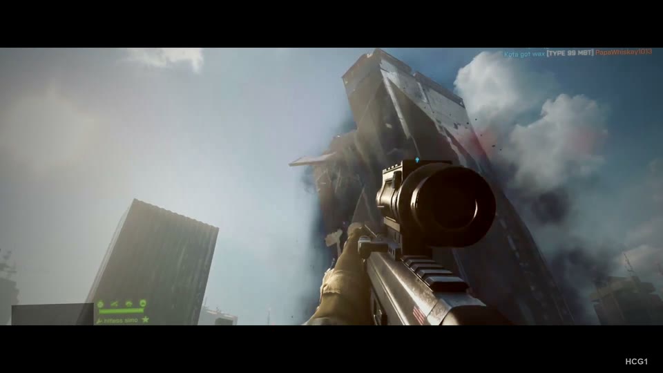 Low-angle rifle view of a damaged skyscraper shedding panels and smoke. Retains cinematic black bars from the finished film.
